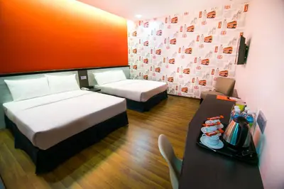 a hotel room with two beds and a table with a tray of food at INDRA HOTEL - BOUTIQUE SUITES in Ipoh