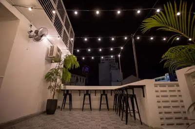a balcony with a bar with stools and lights at The Southern Boutique Hotel in George Town
