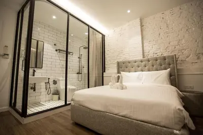a bedroom with a large bed and a shower at The Southern Boutique Hotel in George Town