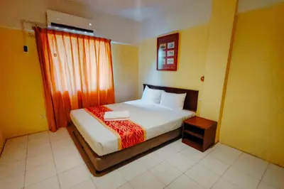 a bedroom with a large bed with a window and a bed sidx sidx at Virgo Batik Resort Teluk Batik Lumut in Lumut