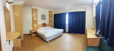 a hotel room with a bed and a desk and a room at Fair Park Hotel in Ipoh