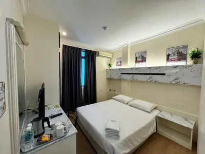 a room with a bed and a desk with a computer at Fair Park Hotel in Ipoh