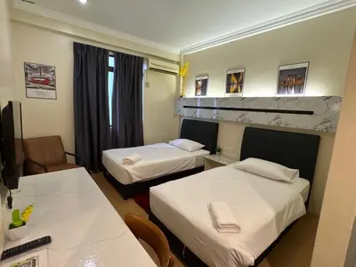 a hotel room with two beds and a table at Fair Park Hotel in Ipoh