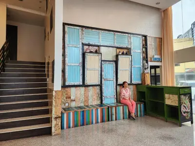a woman sitting on a bench in a building at Fair Park Hotel in Ipoh