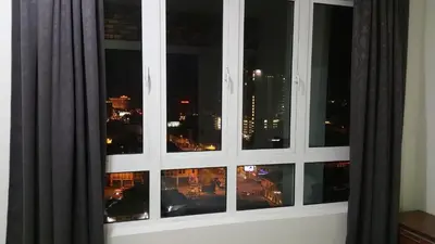 a window with a view of a city at night at The Octagon Ipoh - Home Stay in Ipoh