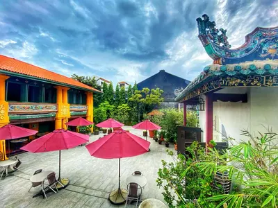 a group of pink umbrellas on a patio at Yeng Keng Hotel in George Town