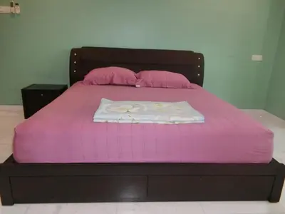 a bed with a pink bedspread and pillows on it at Shuang Yang Sekinchan Homestay 6 in Sekincan