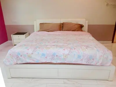 a white bed with a pink comforter on it at Shuang Yang Sekinchan Homestay 6 in Sekincan