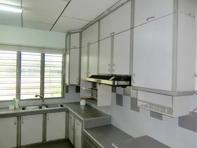 an empty kitchen with white cabinets and a sink at Shuang Yang Sekinchan Homestay 6 in Sekincan