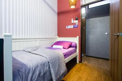 a small bedroom with a bed and a door to a room at USM Designer Dwell in George Town