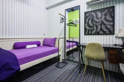 a bedroom with a purple bed and a desk and a chair at USM Designer Dwell in George Town