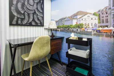 a desk and chair in a room with a view of a river at USM Designer Dwell in George Town
