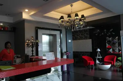 a woman standing at a red counter in a restaurant at De Hotel Ipoh in Ipoh