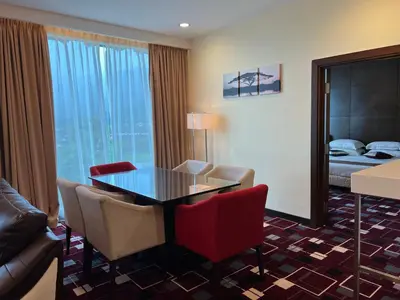 a hotel room with a table and chairs and a bedroom at SSL Traders Hotel in Taiping