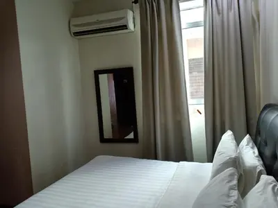 a bedroom with a bed and a mirror and a window at Hotel Seri Pauh in Perai