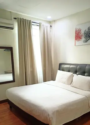 a bedroom with a bed with white sheets and a window at Hotel Seri Pauh in Perai