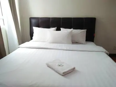 a white blanket with a ring on it on a bed at Hotel Seri Pauh in Perai