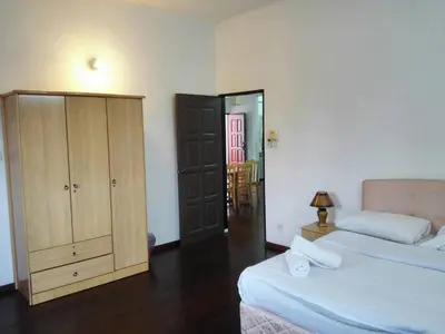 a bedroom with two beds and a cabinet and a mirror at Lumut Titi Panjang Apartment in Lumut
