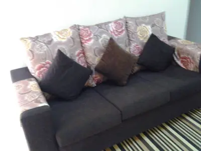 a couch with several pillows on it in a living room at Alisa Homestay in Sungkai