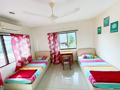 a living room with two beds and a table at Buntong Homestay -Rooms Only in Ipoh