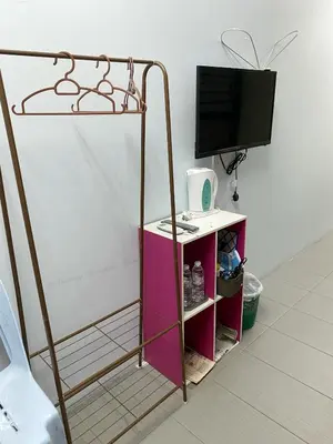 a room with a tv and a table with a shelf at Buntong Homestay -Rooms Only in Ipoh