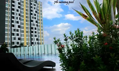 a swimming pool with two tall buildings and some plants at H2H - Marine Home @ Majestic Ipoh (8~10 Guests) in Ipoh