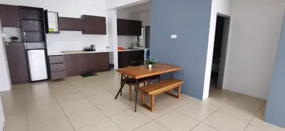 a kitchen with a wooden table and a small table and chairs at My 4Rooms Apartment @ Golden Hills Pasar Malam in Cameron Highlands