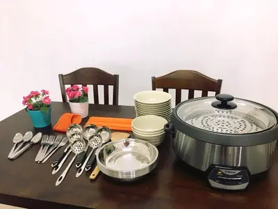 a table with a slow cooker and plates and utensils at W9 atGoldenHills NightMarket WiFi 4R BBQ in Cameron Highlands