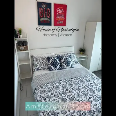 a bedroom with a bed and a sign on the wall at House Of Nostalgia in Lumut