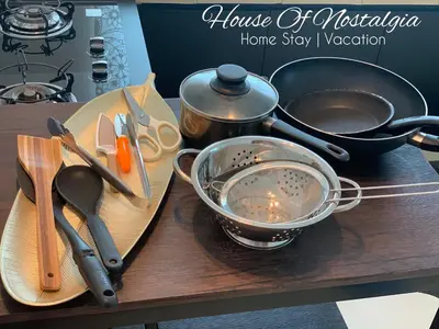 a wooden table with utensils and a home stay version of a kitchen at House Of Nostalgia in Lumut