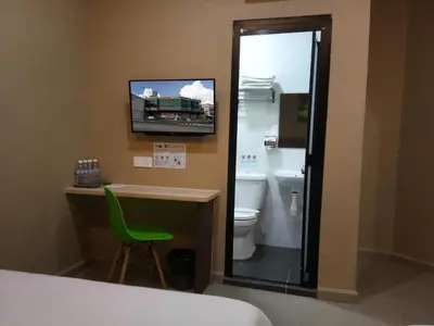 a bathroom with a toilet and a tv on the wall at Asiago Hotel in Sungai Petani