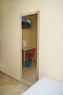 a mirror in a room with a table and a chair at Asiago Hotel in Sungai Petani