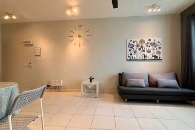a living room with a couch and a clock on the wall at Moderm Spacious 6pax S PICE Penang in Bayan Lepas