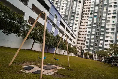 three swings in a park in front of a building at Moderm Spacious 6pax S PICE Penang in Bayan Lepas
