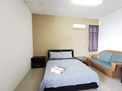 a bedroom with a bed and a blue couch at Sea Lion by the beach in George Town