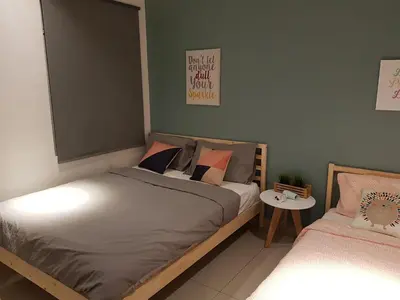 a bedroom with two beds and a small table at Nordiska @ Majestic Ipoh in Ipoh
