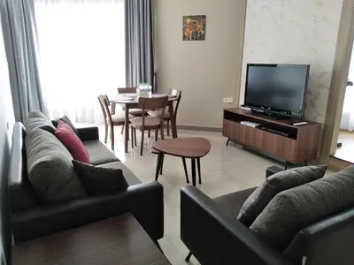 a living room with a couch and a tv and a table at The Octagon Ipoh in Ipoh