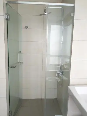 a shower with a glass door next to a sink at The Octagon Ipoh in Ipoh