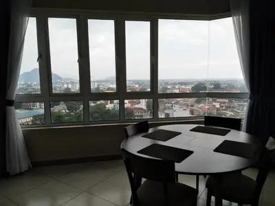 a table and chairs in a room with a large window at The Octagon Ipoh in Ipoh