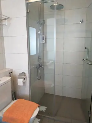 a bathroom with a glass shower with a toilet at The Octagon Ipoh in Ipoh