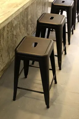 a row of black stool sitting next to a counter at Stay SongSong Beach Street in George Town