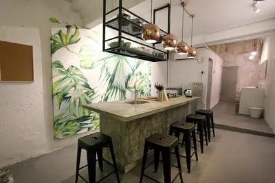 a kitchen with a counter with stools and a sink at Stay SongSong Beach Street in George Town