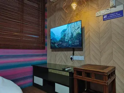 a bedroom with a flat screen tv on a wall at SECRET STUDIO On Factory in George Town