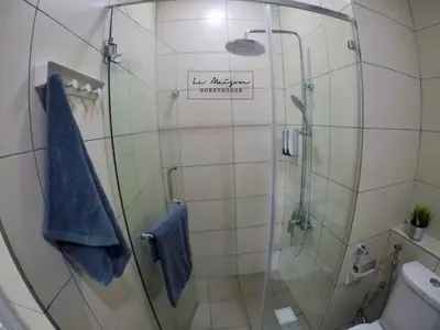 a bathroom with a shower with a blue towel at Le Maison GuestHouse Ipoh @ Octagon in Ipoh