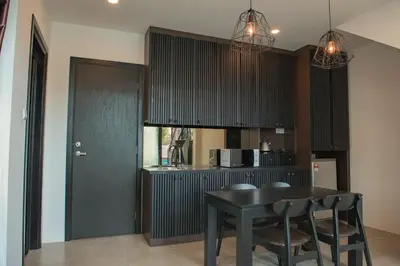 a kitchen with a black table and chairs at Hermitage Boutique House in Taiping