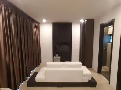 a white couch in a room with curtains at Hermitage Boutique House in Taiping