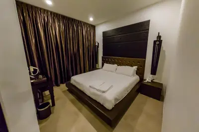a bedroom with a bed and a window with curtains at Hermitage Boutique House in Taiping