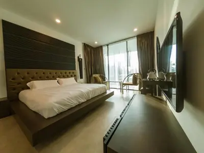 a bedroom with a large bed and a desk at Hermitage Boutique House in Taiping