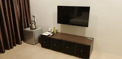 a living room with a flat screen tv on a wall at Hermitage Boutique House in Taiping