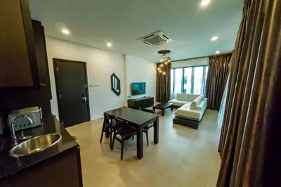 a kitchen and living room with a table and a couch at Hermitage Boutique House in Taiping